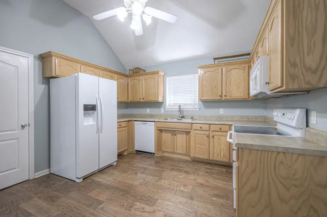 a kitchen with stainless steel appliances granite countertop a refrigerator sink and cabinets