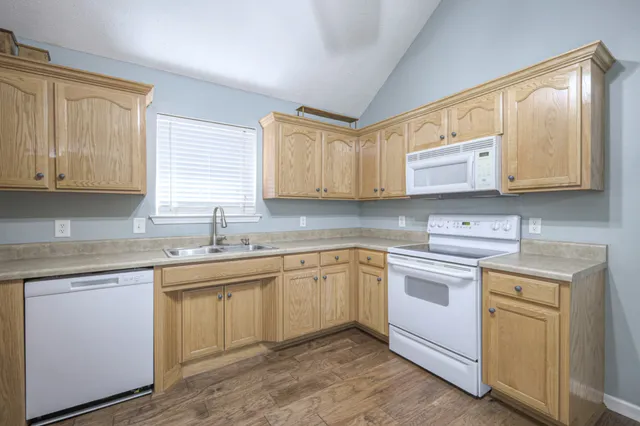 a kitchen with stainless steel appliances granite countertop a sink stove and cabinets
