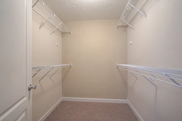 a view of walk in closet with empty racks