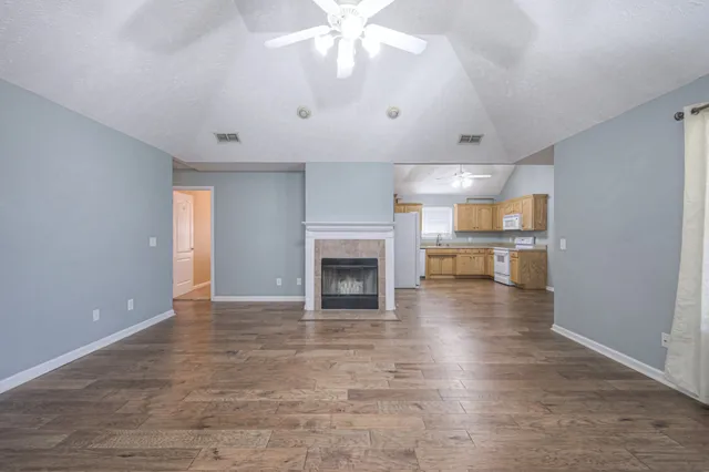 an empty room with kitchen and fireplace