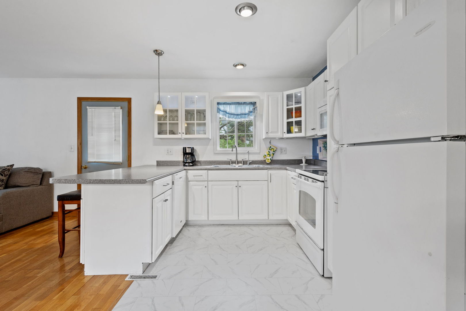 7134 North Bull Creek Road Grant Park, IL 60940 - Photo 17 of 46 a kitchen with white cabinets and white appliances