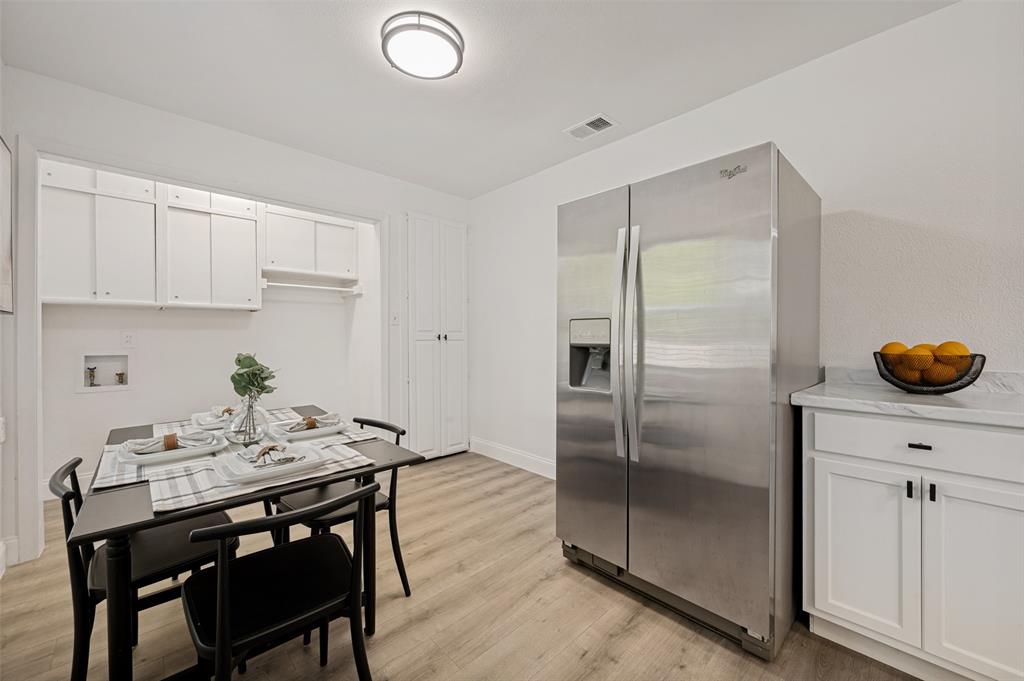 2316 Cunningham Street Irving, TX 75062 - Photo 9 of 22 Kitchen dining area featuring wood-finish flooring and a stainless steel side-by-side refrigerator