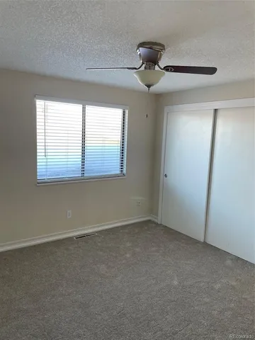 en empty room with windows and ceiling fan