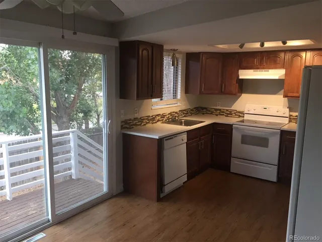 a kitchen with a stove and a wooden floor