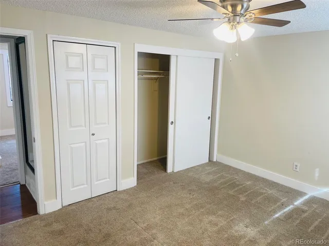 an empty room with closet and a chandelier fan