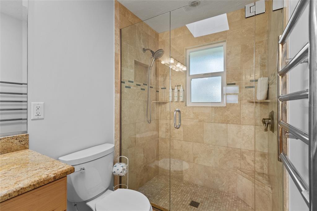 315 Spring Avenue Anna Maria, FL 34216 - Photo 30 of 63 a bathroom with a granite countertop shower a toilet and a sink