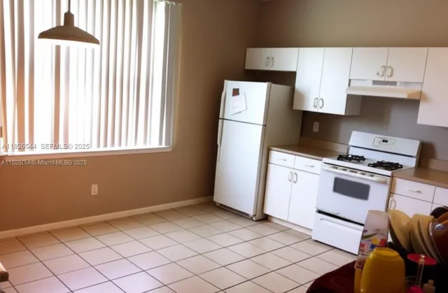 a kitchen with a stove a refrigerator and a window