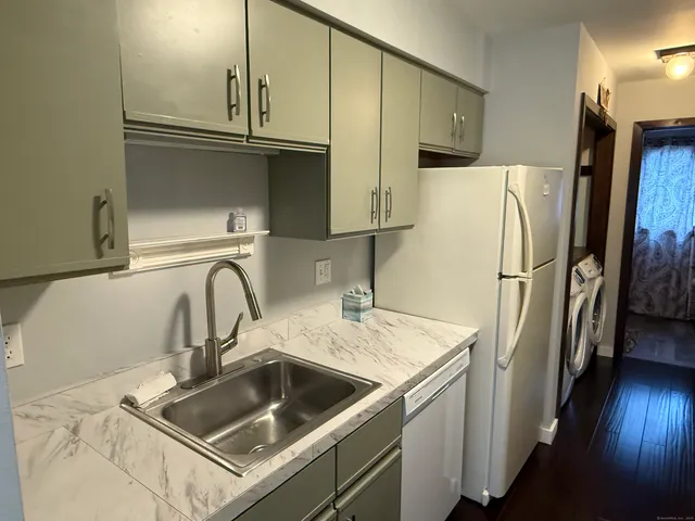 a kitchen with stainless steel appliances granite countertop a refrigerator a sink and a stove