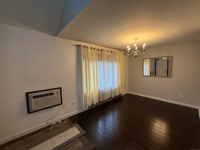 a view of a room with wooden floor staircase and a window