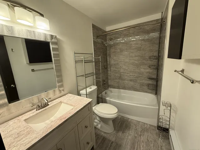a bathroom with a sink a toilet and shower
