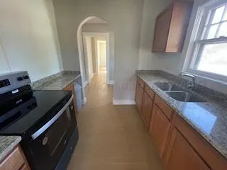 a kitchen with granite countertop a sink stove and cabinets