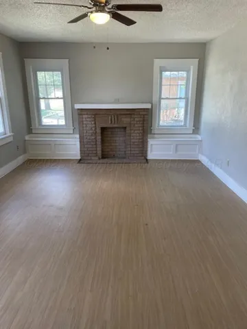 an empty room with windows and fireplace