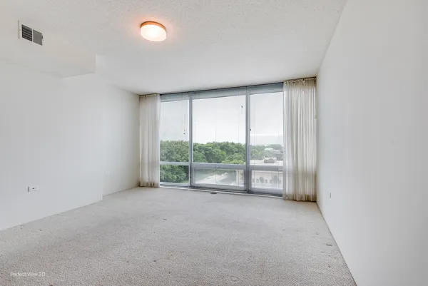 an empty room with large windows and garden view