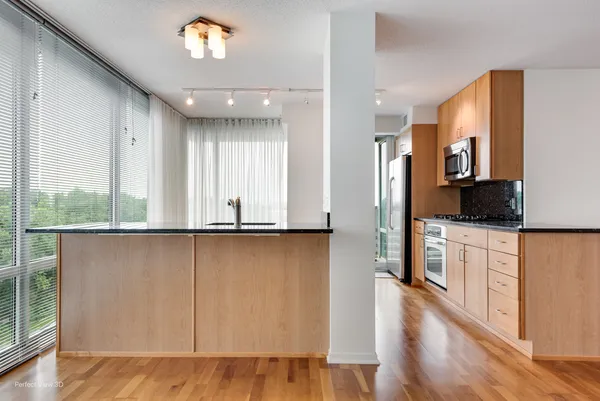 a view of kitchen with wooden floor and electronic appliances