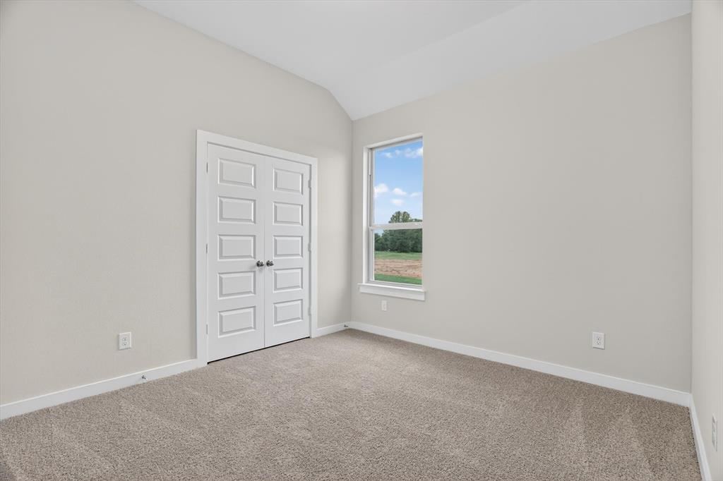 321 Skeen Peak Springtown, TX 76082 - Photo 26 of 37 Vaulted ceiling room featuring light neutral wall tones, plush carpeting, white baseboards, and a large window with outdoor scenery
