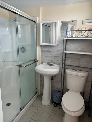 a bathroom with a toilet sink and shower