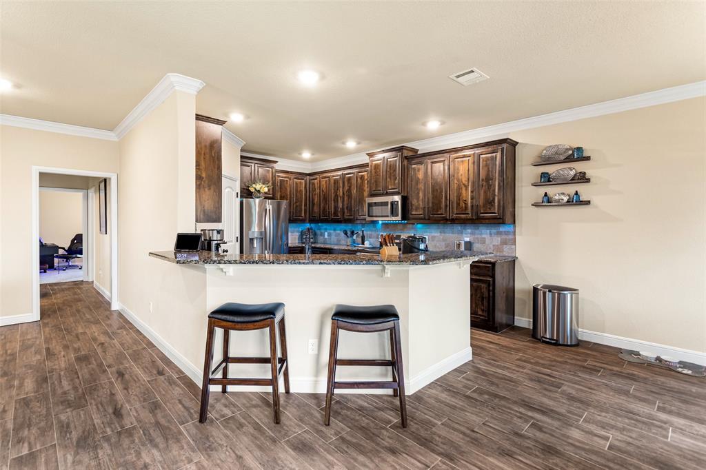 223 Cottongame Road Weatherford, TX 76088 - Photo 10 of 35 a kitchen with kitchen island a white cabinets and refrigerator