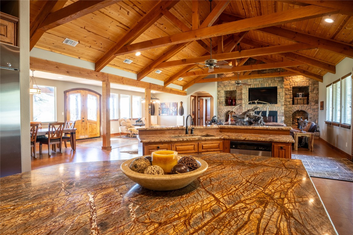 5525 Fm2340 Road Burnet, TX 78611 - Photo 39 of 39 Kitchen featuring arched walkways, open floor plan, brown cabinets, dark stone counters, and wooden ceiling