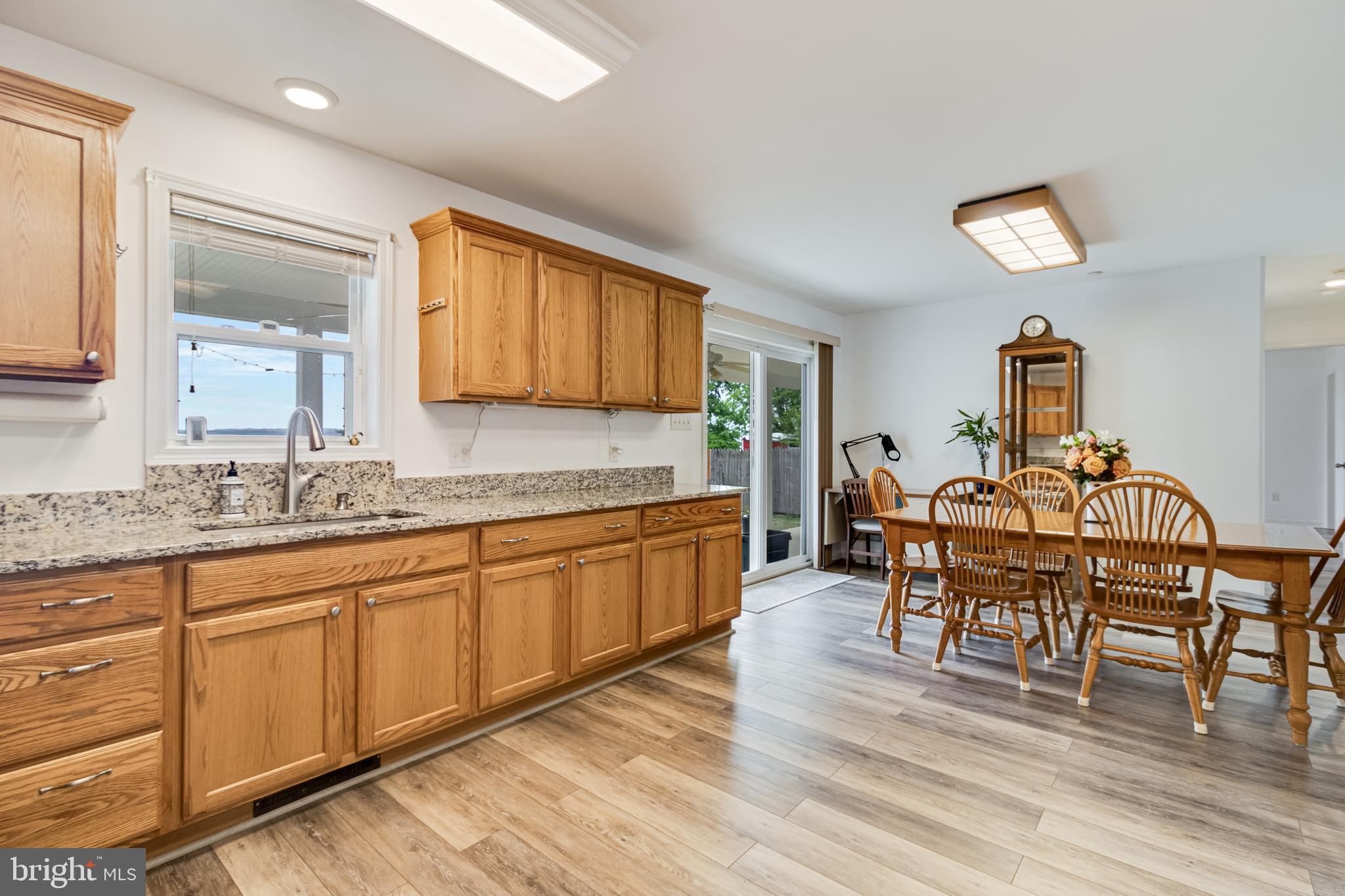 12015 Woodbury Road Nanjemoy, MD 20662 - Photo 20 of 53 a kitchen with granite countertop a dining table chairs cabinets wooden floor and appliances