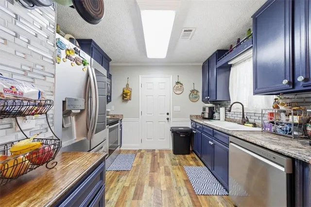 a kitchen with stainless steel appliances granite countertop a sink dishwasher stove and refrigerator