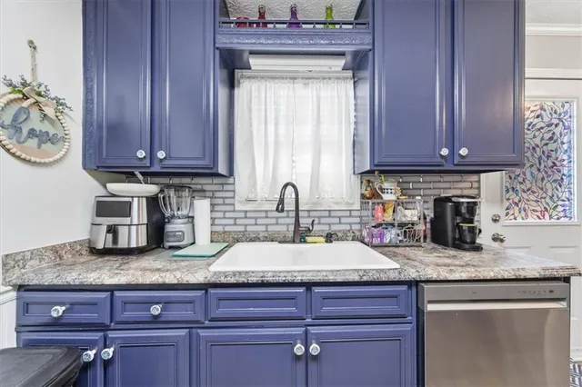 a kitchen with granite countertop wooden cabinets a sink and dishwasher
