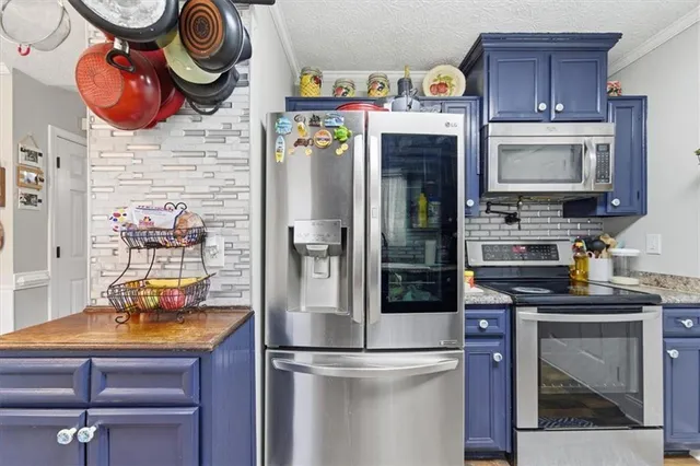 a kitchen with stainless steel appliances granite countertop a refrigerator a stove and a sink with wooden floor