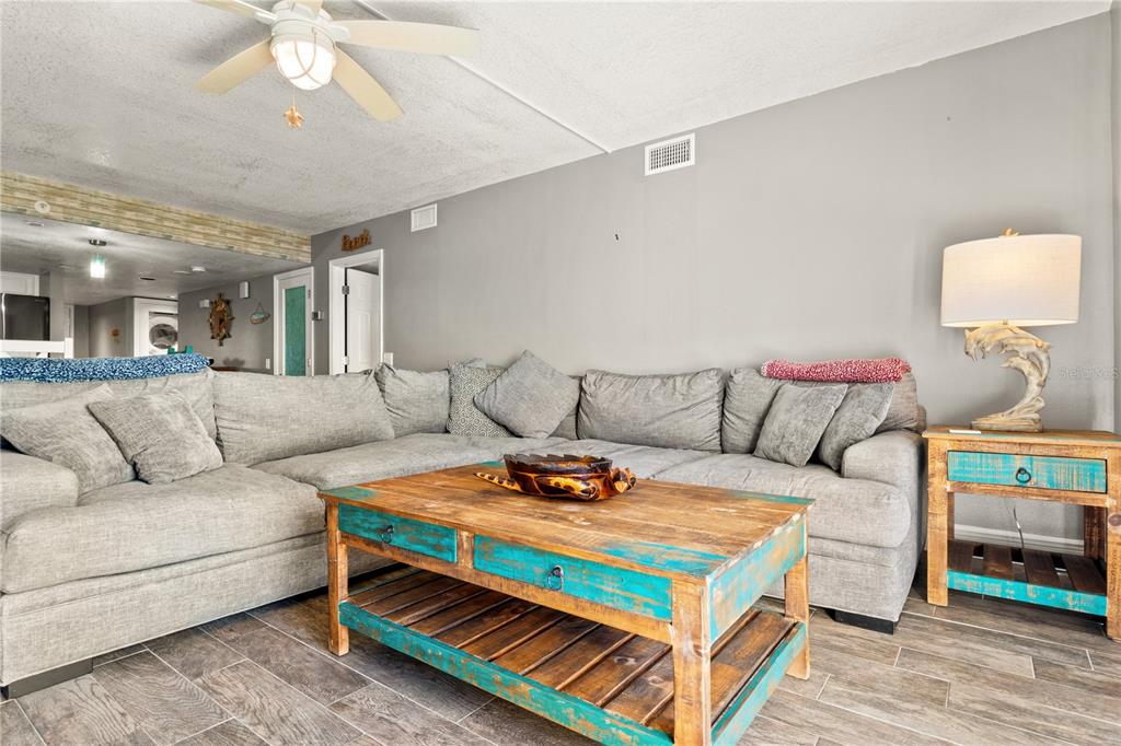 6035 Sea Ranch Drive, Unit 415 Hudson, FL 34667 - Photo 14 of 49 a living room with furniture and a chandelier
