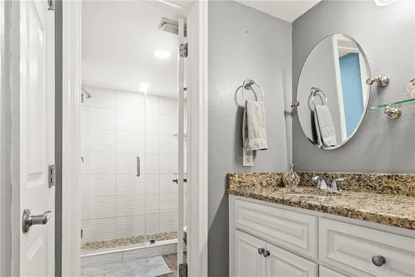 a bathroom with a granite countertop sink vanity and mirror