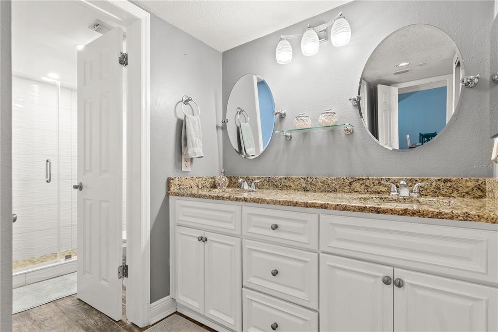 6035 Sea Ranch Drive, Unit 415 Hudson, FL 34667 - Photo 27 of 49 a bathroom with a granite countertop sink vanity and mirror