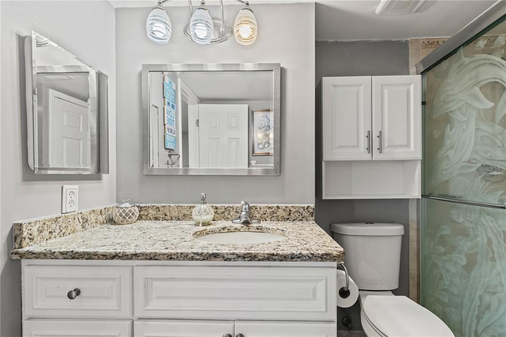 6035 Sea Ranch Drive, Unit 415 Hudson, FL 34667 - Photo 32 of 49 a bathroom with a granite countertop toilet sink and mirror