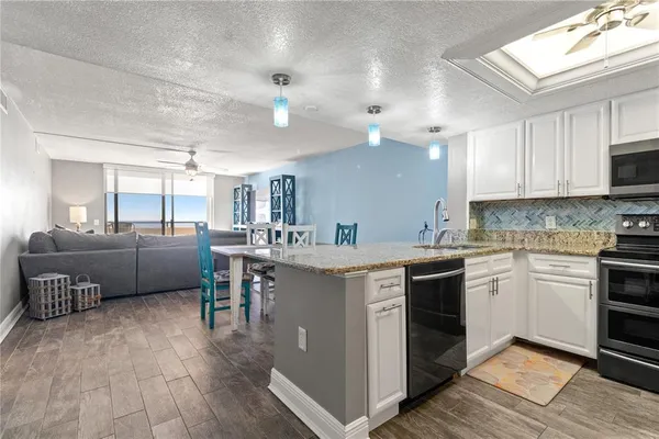 a kitchen with furniture a counter top space a sink stainless steel appliances and cabinets