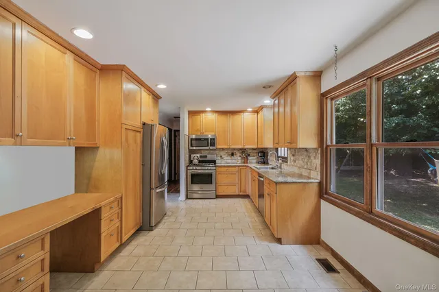 a kitchen with stainless steel appliances a refrigerator and wooden cabinets