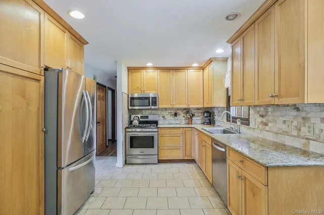 a dining hall with stainless steel appliances granite countertop a stove and a refrigerator