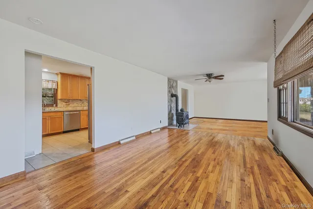 a very nice looking room with wooden floor and a ceiling fan
