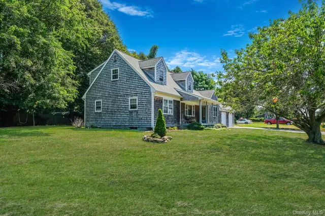 a front view of a house with yard and green space