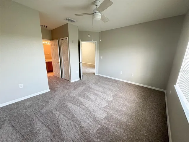 an empty room with closet and windows