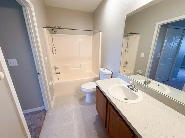 a bathroom with a sink a toilet a mirror and shower