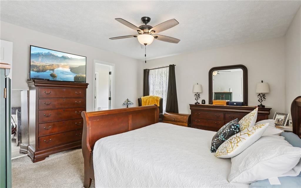 9725 Kings Road Gainesville, GA 30506 - Photo 14 of 32 a bedroom with a bed and ceiling fan