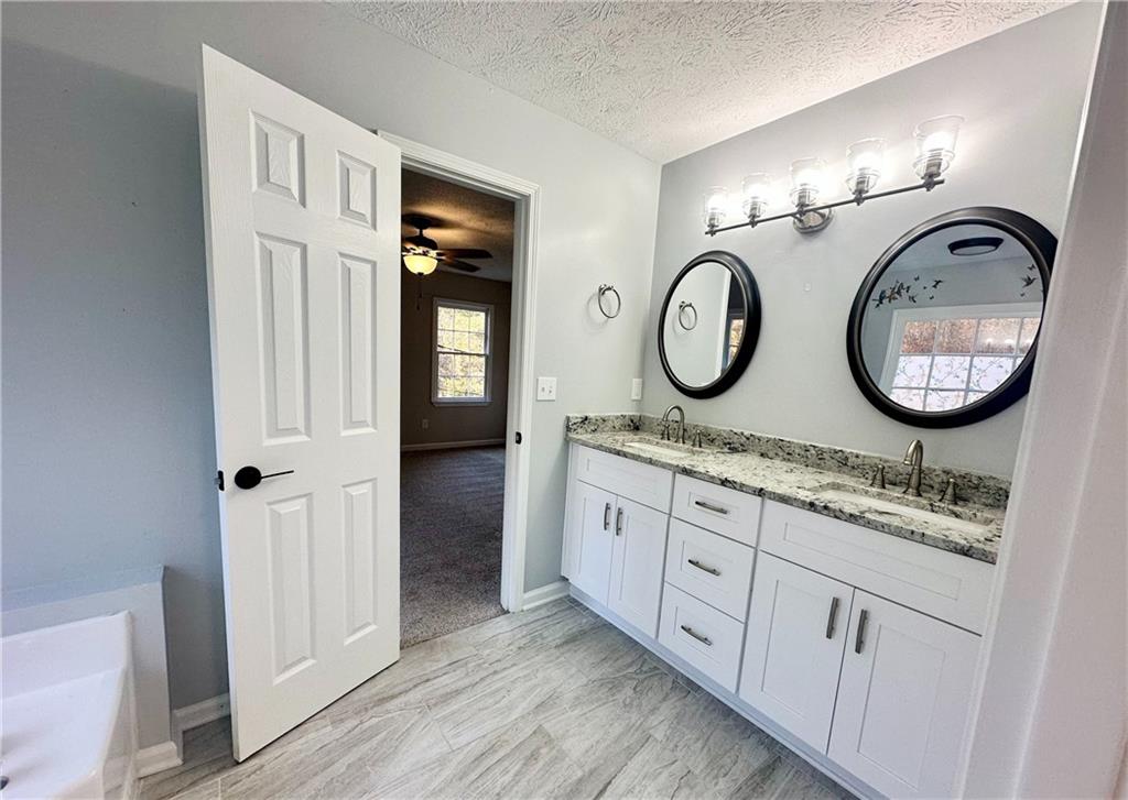 9725 Kings Road Gainesville, GA 30506 - Photo 16 of 32 a bathroom with a granite countertop double vanity sink and a mirror