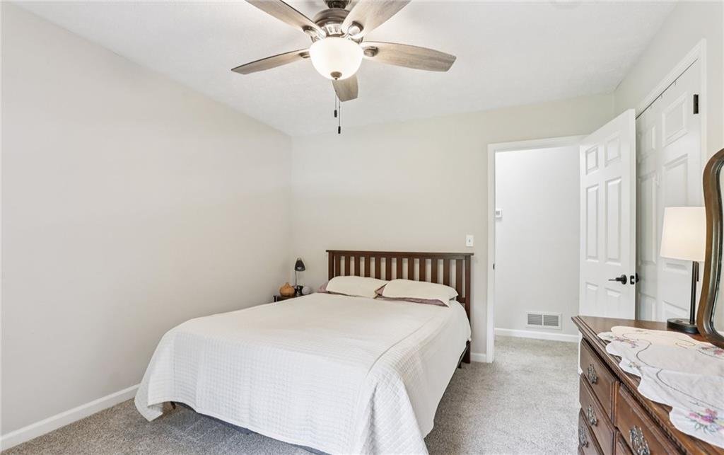 9725 Kings Road Gainesville, GA 30506 - Photo 21 of 32 a bedroom with a bed and a chandelier