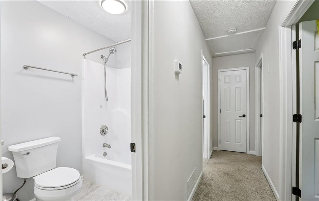 9725 Kings Road Gainesville, GA 30506 - Photo 23 of 32 a bathroom with a toilet and a shower