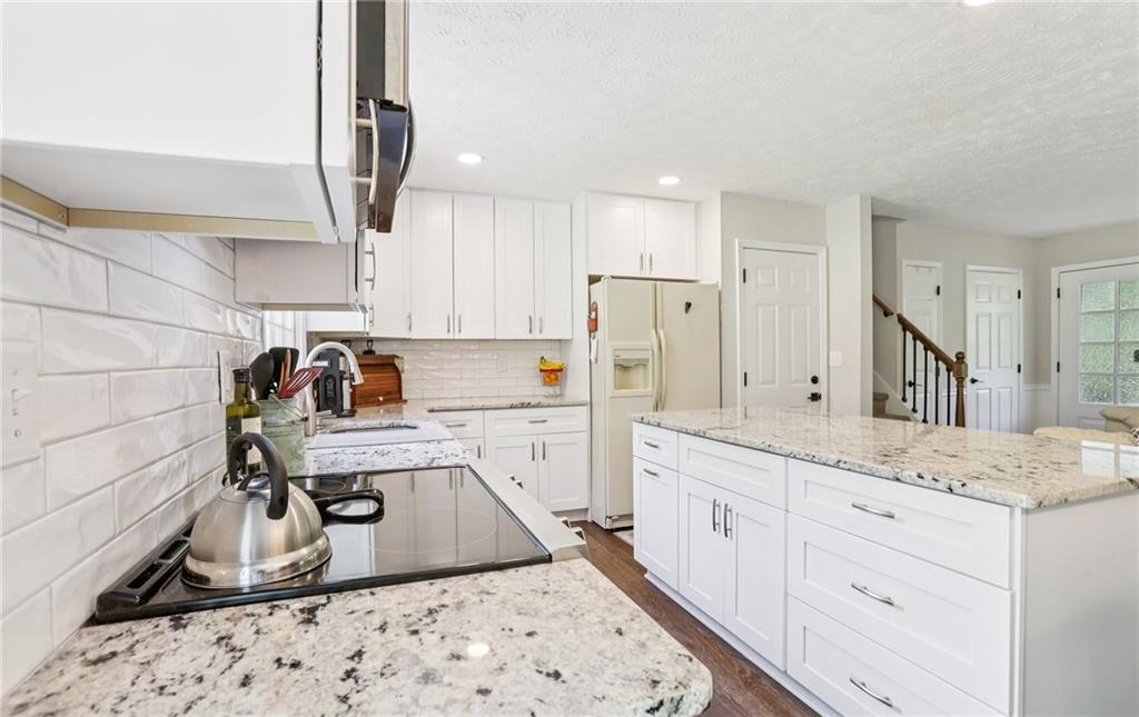 9725 Kings Road Gainesville, GA 30506 - Photo 26 of 32 a kitchen with white cabinets sink and refrigerator
