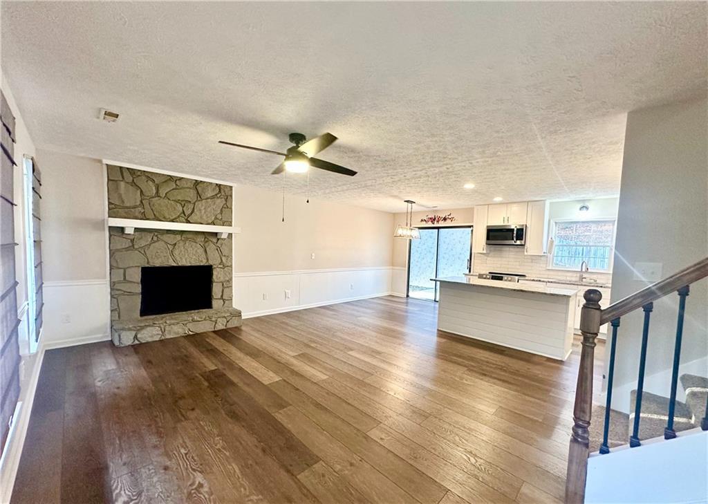 9725 Kings Road Gainesville, GA 30506 - Photo 6 of 32 a view of a hallway with wooden floor and a fireplace
