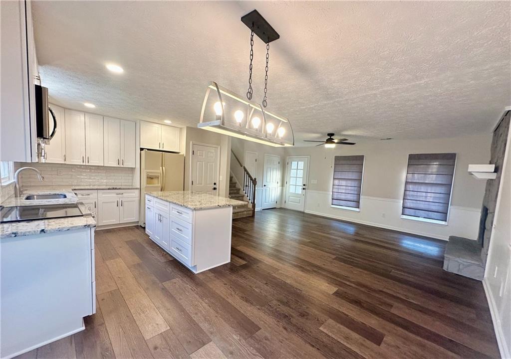 9725 Kings Road Gainesville, GA 30506 - Photo 9 of 32 a kitchen with stainless steel appliances granite countertop a lot of counter space and wooden floors