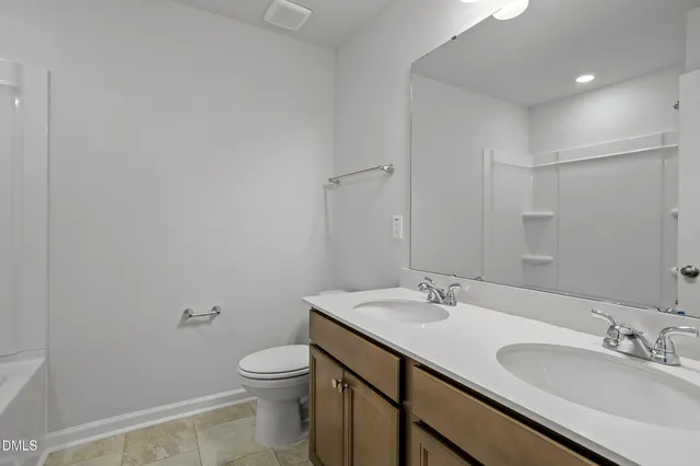 a bathroom with a granite countertop sink a toilet and a mirror