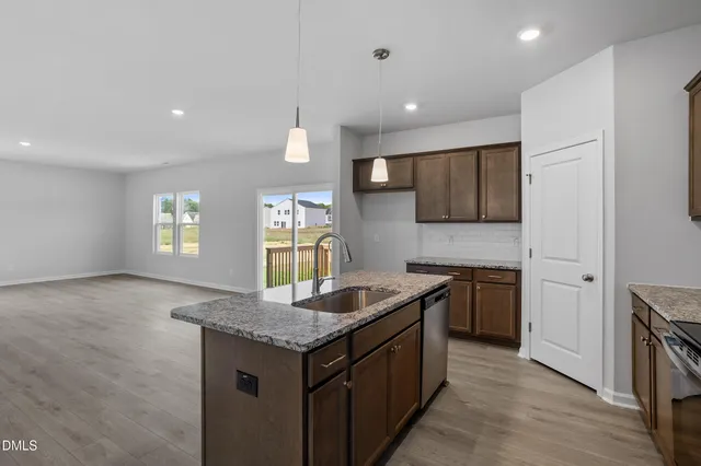 a kitchen with granite countertop kitchen island stainless steel appliances a sink stove and refrigerator