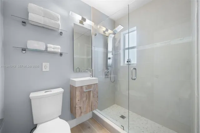 a bathroom with a shower a toilet and sink
