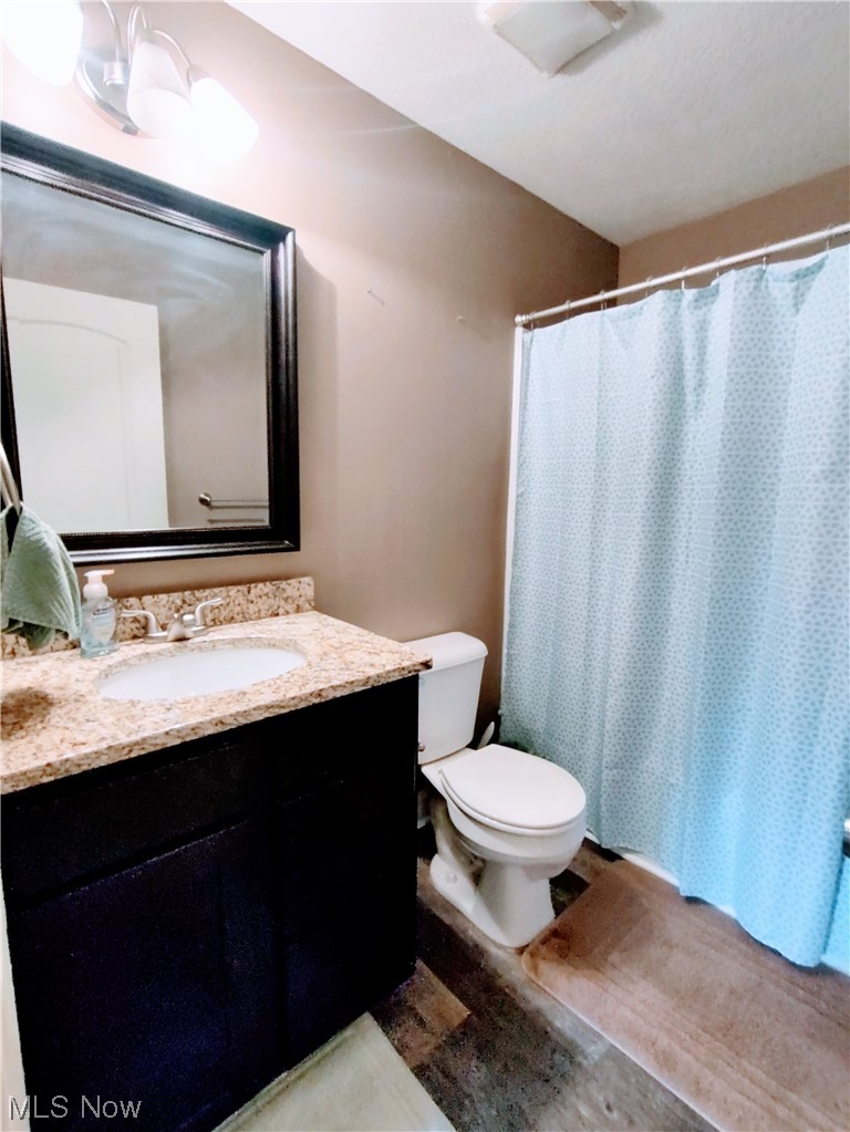 1468 Steese Road Uniontown, OH 44685 - Photo 13 of 28 Bathroom featuring vanity, toilet, and a notable chandelier