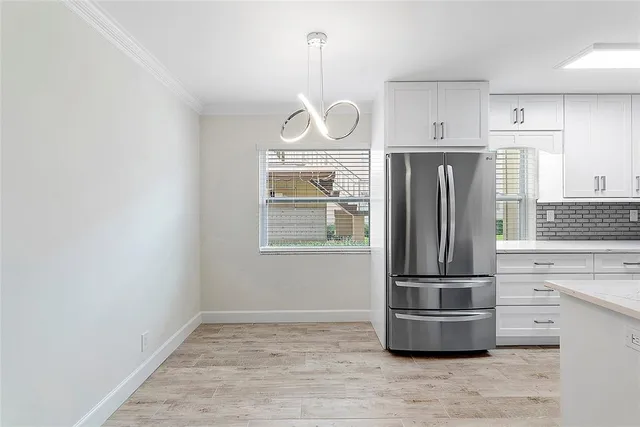 a kitchen with kitchen island wooden cabinets and a refrigerator