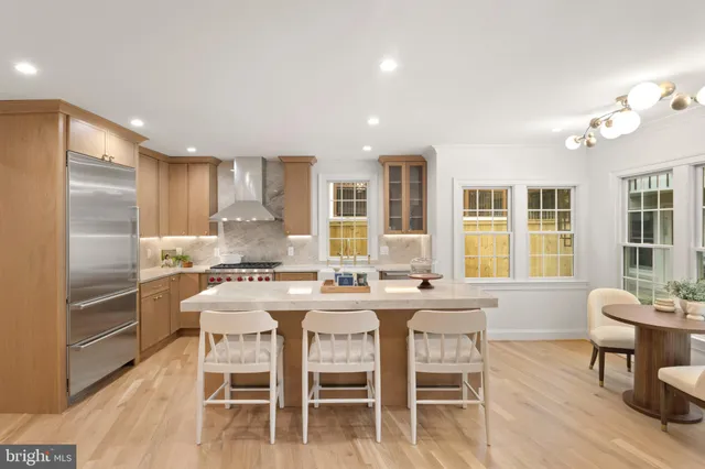 a kitchen with kitchen island a dining table and chairs